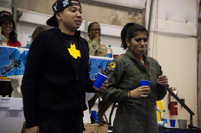 Airman Michael Gibson and 2nd Lt. Sarah D’Alessandro, 50th Force Support Squadron, drink some of the grog concoction during the 2016 Combat Dining Out at Schriever Air Force Base, Colorado, April 15, 2016. Attendees dressed up in a combination of military uniform from any era and their favorite superheroes. (U.S. Air Force photo/Tech. Sgt. Julius Delos Reyes)
