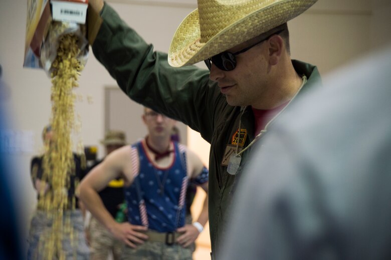 Maj. Rodney Lambert, 50th Contracting Squadron commander, pours breakfast cereal into the grog during the 2016 Combat Dining Out at Schriever Air Force Base, Colorado, Friday, April 15, 2016. The Air Force tradition included the basic rules of engagement and grog bowl procedures during a typical dining out. (U.S. Air Force photo/Tech. Sgt. Julius Delos Reyes)