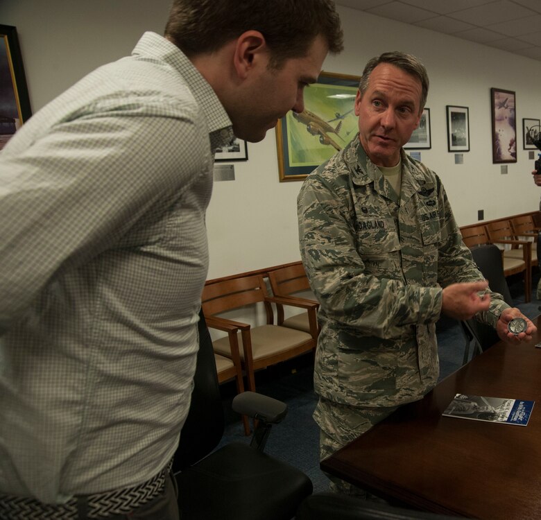 Col. Bradley Hoagland, 11th Wing and Joint Base Andrews commander, explains the meaning of the commander’s coin to James David Andrews V, on JBA, Md., April 14, 2016. Andrews, the great-great nephew of deceased Lt. Gen. Frank M. Andrews and whom the base is named after, was presented the coin. (U.S. Air Force photo by Airman Gabrielle Spalding/Released)