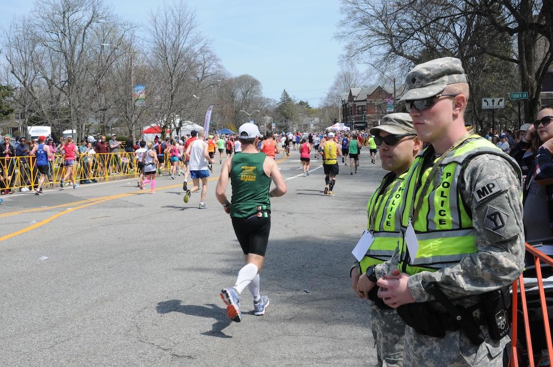 Army Spcs. Mark Mahoney and Kevin O'Donnell stand along Commonwealth Avenue providing security in support of local and state police during the 120th Boston Marathon in Newton, Mass., April 18, 2016. Mahoney and O’Donnell are military policemen assigned to the Massachusetts Army National Guard’s 772 Military Police Company. Massachusetts Army National Guard photo