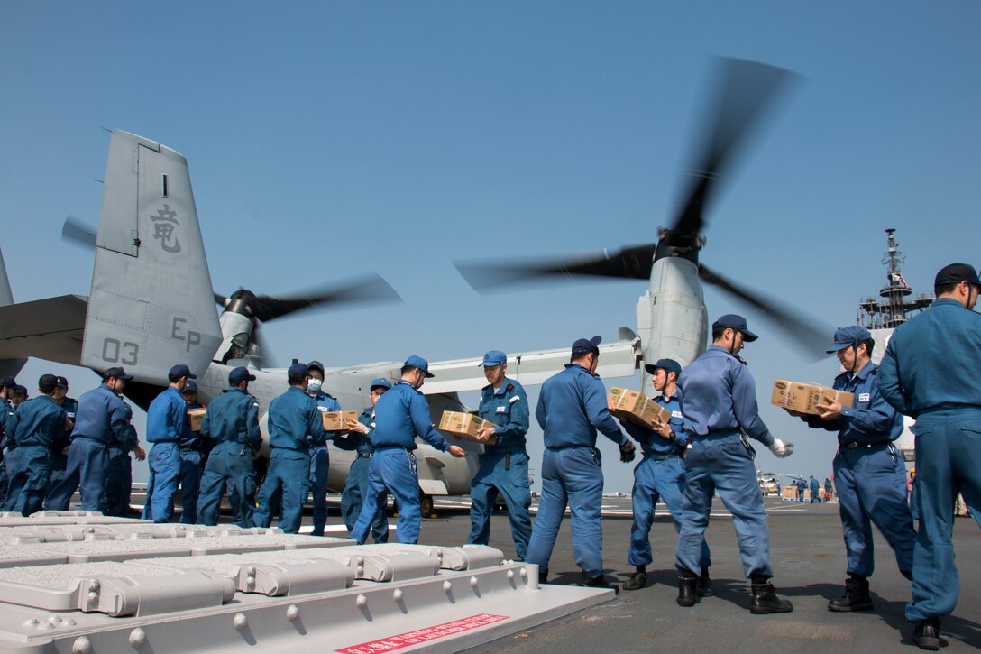 Japan Maritime Self-Defense Force members form a line to load earthquake relief supplies into a U.S. Marine Corps MV-22B Osprey aircraft aboard the JS Hyuga near Kumamoto, Japan, April 19, 2016. Navy photo by Petty Officer 3rd Class Gabriel B. Kotico