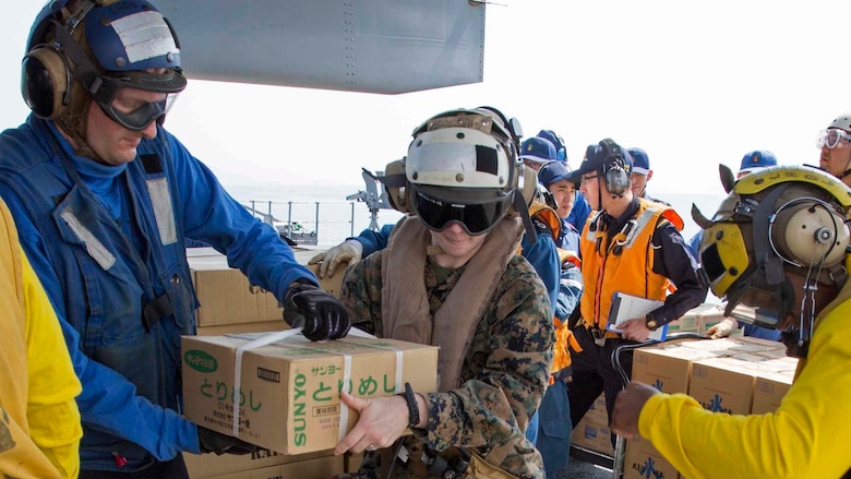 U.S. Marine Corps Sgt. Ginger Jordan, a maintenance administrative specialist assigned to Marine Medium Tiltrotor Squadron 265, 31st Marine Expeditionary Unit, loads supplies onto a MV-22B Osprey tiltrotor aircraft with U.S. Navy sailors and Japan Maritime Self Defense Force personnel aboard the JS Hyuga (DDH 181), at sea, April 20, 2016. The supplies are in support of the relief effort after a series of earthquakes struck the island of Kyushu. The 31st MEU is the only continually forward-deployed MEU and remains the Marine Corps' force-in-readiness in the Asia-Pacific region. 