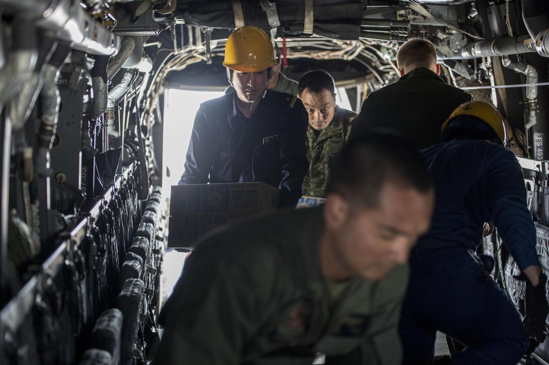 Japanese service members and U.S. Marines load supplies into a U.S. Marine Corps MV-22B Osprey aircraft at Marine Corps Air Station Iwakuni, Japan, April 20, 2016. Marine Corps photo by Cpl. Nathan Wicks