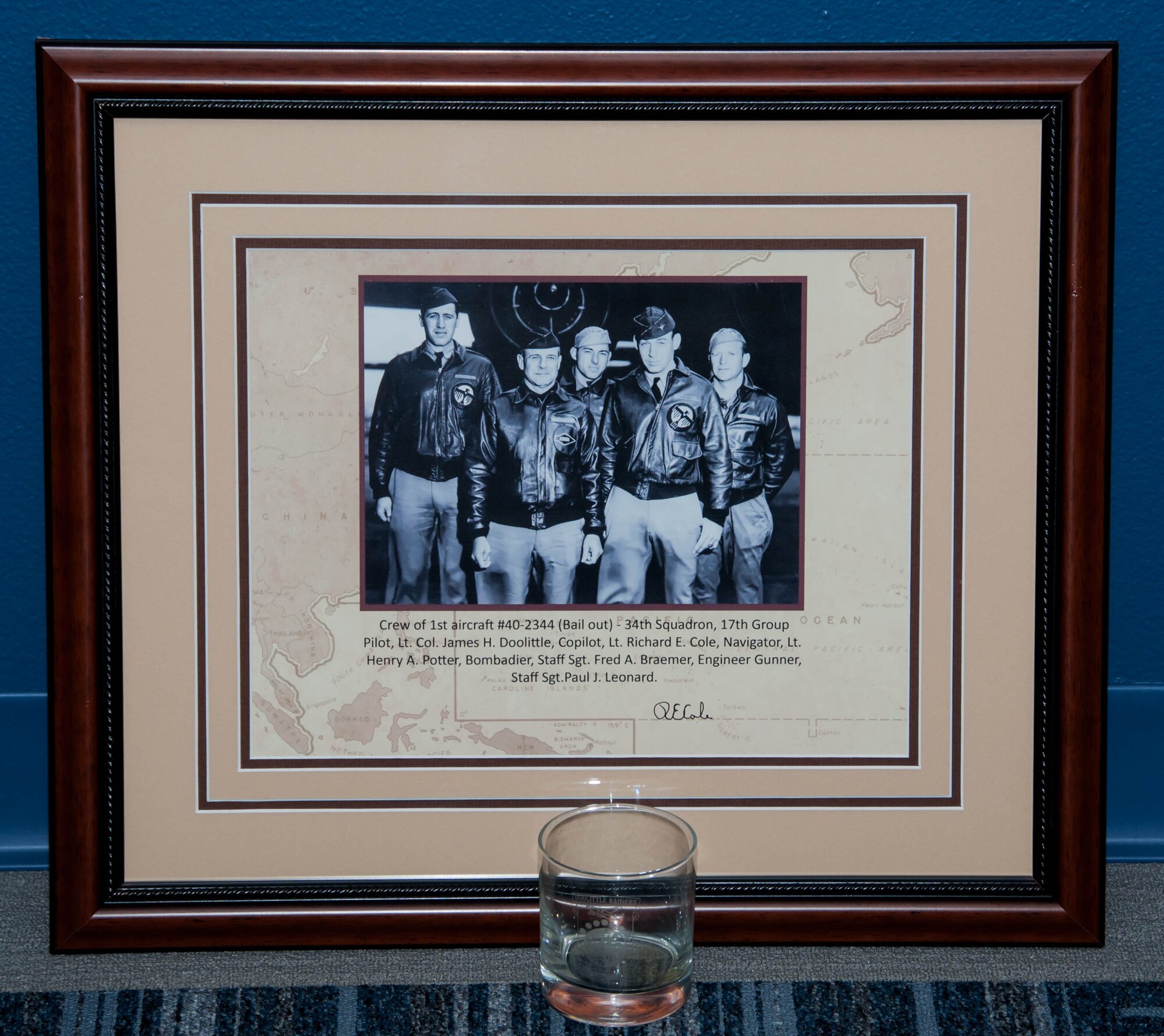 A framed picture signed by Lieutenant Colonel Richard Cole, one of the two Doolittle's Raiders still alive, and a glass etched with the Doolittle Raiders’ patch was displayed at the BUFF Event Center at Barksdale Air Force Base, La, April 18, 2016, during the annual commemorative toast in honor of the Doolittle Tokyo Raid. The toast is an annual tradition of the Doolittle Raiders for the surviving Raiders to honor those who had died. (U.S. Air Force photo by Master Sgt. Laura Siebert/Released)