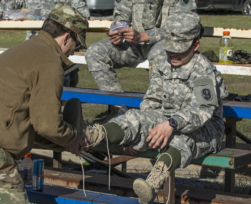 Spc. Kayla Bundy, 1st Bn., 414th Inf. Reg., 95th Training Division (IET), gets a bit of help removing her boots after completing a 10-mile forced march during the 2016 108th Training Command (IET) Best Warrior competition held at Fort Jackson, S.C., March 21. This year's Best Warrior competition determined the top NCO and junior enlisted Soldier who will represent the 108th Training Command (IET) at the Army Reserve Drill Sgt. of the Year competition later this year at Fort Bragg, N.C. Bundy was selected to represent the 108th in the junior enlisted competition. (U.S. Army photo by Sgt. 1st Class Brian Hamilton/released)