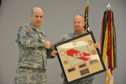 Army Reserve Command Sgt. Maj. Scott A. Hinton, 643rd Regional Support Group senior enlisted advisor, presents Col. William J. McLaen with a commemorative guidon during a change of command ceremony April 9, at the unit’s Whitehall, Ohio, Army Reserve Center headquarters. McLaen, outgoing commander of the 643rd RSG, is relinquishing command to incoming commander, Col. Stephen R. Smith.