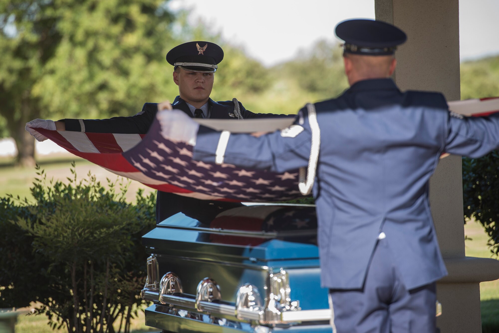 Senior Airman Adam Fiddler and a fellow Joint Base San Antonio Honor Guard member fold an American Flag during a funeral ceremony Oct. 10 at the Fort Sam Houston National Cemetery. The Honor Guard's primary mission is to pay respect to fallen service members and support ceremonial functions. 