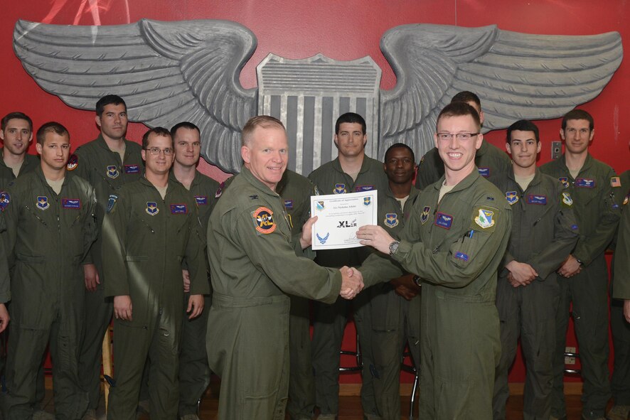1st Lt. Nicholas Atkins, 434th Flying Training Squadron X-Flight unit standardization and evaluation manager and T-6 Texan II instructor pilot, accepts the “XLer of the Week” award from Col. Darrell Judy, 47th Flying Training Wing vice commander, here, April 11, 2016. The XLer is a weekly award chosen by wing leadership and is presented to those who consistently make outstanding contributions to their unit and Laughlin. (U.S. Air Force photo by Airman 1st Class Brandon May)