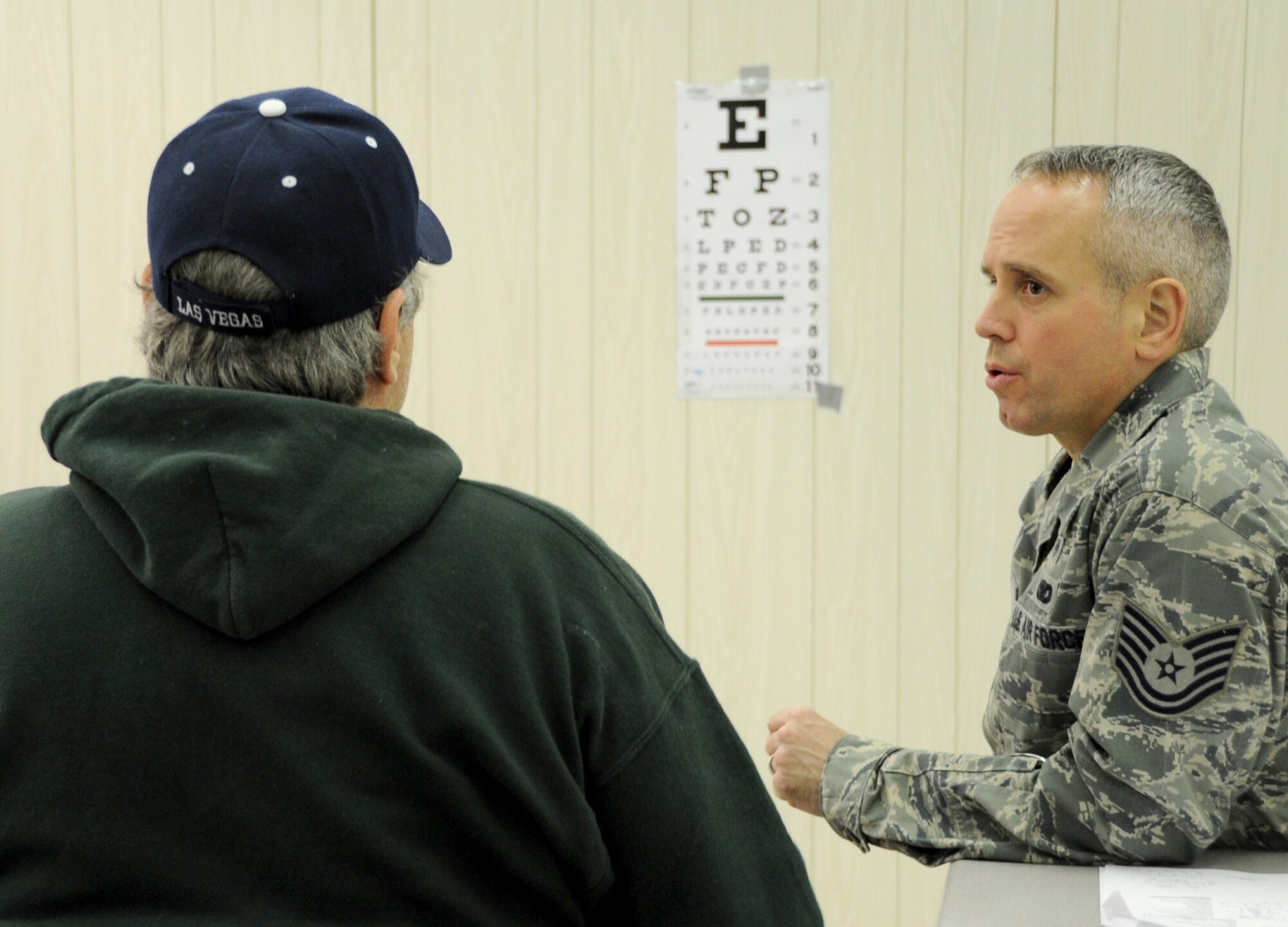 Tech. Sgt. John Murphy, an ophthalmic technician assigned to the 911th Aeromedical Staging Squadron, Pittsburgh International Airport Air Reserve Station, Pennsylvania, talks with a patient during Arctic Care 2016 in Kodiak, Alaska. (U.S. Air Force photo by Bo Joyner)