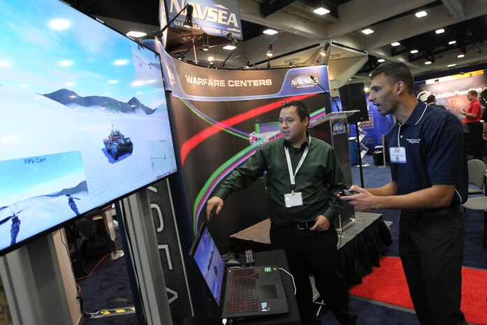 160217-N-HW977-232 SAN DIEGO, Calif. (Feb. 17, 2015) Eric Morales, left, a Naval Surface Warfare Center (NSWC), Corona Division engineer, shows a virtual demonstration of a Cycloptic Scoring System (CYCLOPSS) to Kushan Patel, of Georgia Tech Research Institute, during WEST 2016, a three-day conference co-sponsored by Armed Forces Communications and Electronics Association (AFCEA) and U.S. Naval Institute (USNI). Earlier Rear Adm. Lorin Selby, NSWC Commander, highlighted the intellectual capital of the warfare centers and their capability to deliver innovative technology to the warfighter. (U.S. Navy photo by Greg Vojtko/Released)