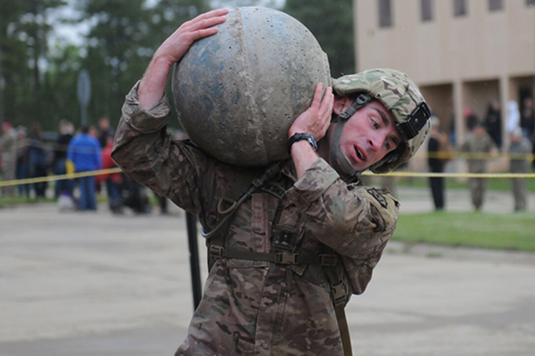 Army Capt. Brian Slamkowski carries a 135-pound cement ball during the first day of the Best Ranger Competition at Fort Benning, Ga., April 15, 2016. Slamkowski is assigned to the Maneuver Center of Excellence. DoD photo by Katie Lange