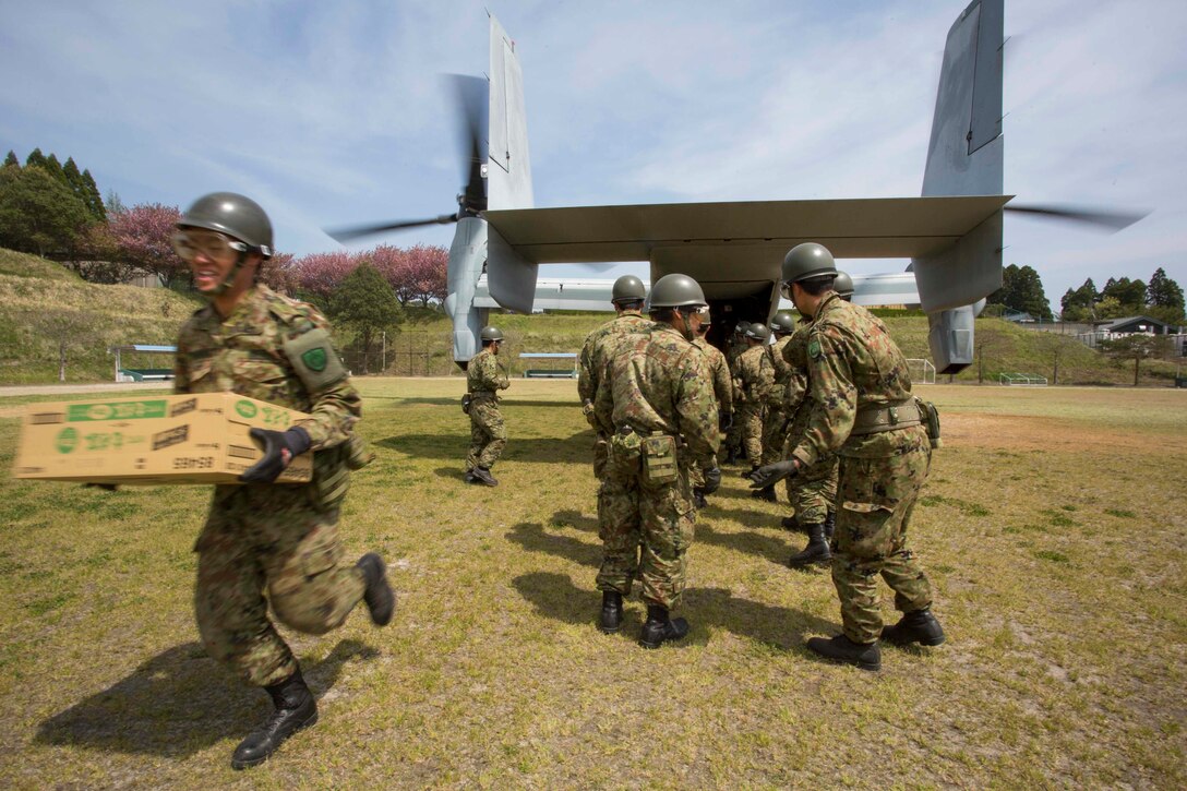 Japanese soldiers unload humanitarian aid from a U.S. Marine Corps MV-22B Osprey aircraft at the Hakusui Sports Park on Kyushu island, Japan, April 20, 2016. The aircraft is assigned to Marine Medium Tiltrotor Squadron 265, 31st Marine Expeditionary Unit. The humanitarian aid is part of relief efforts after a series of earthquakes struck the island. Marine Corps photo by Cpl. Darien J. Bjorndal