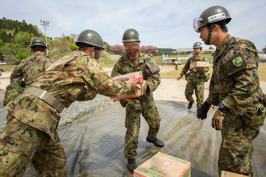 Japanese soldiers unload humanitarian aid from a U.S. Marine Corps MV-22B Osprey aircraft at the Hakusui Sports Park, Kyushu island, Japan, April 20, 2016. Marine Corps photo by Cpl. Darien J. Bjorndal