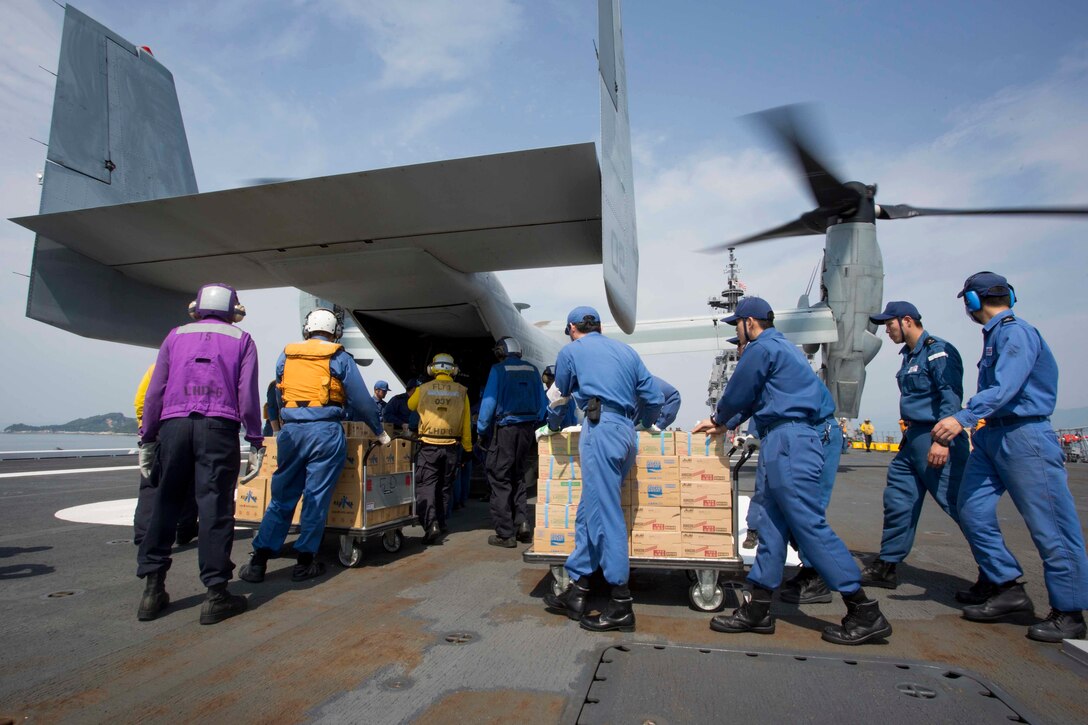 Japan Maritime Self-Defense Force members, U.S. Navy sailors and U.S. Marines load supplies onto a U.S. Marine Corps MV-22B Osprey aboard the JS Hyuga at sea, near Kumamoto, Japan, April 20, 2016. Marine Corps photo by Cpl. Darien J. Bjorndal