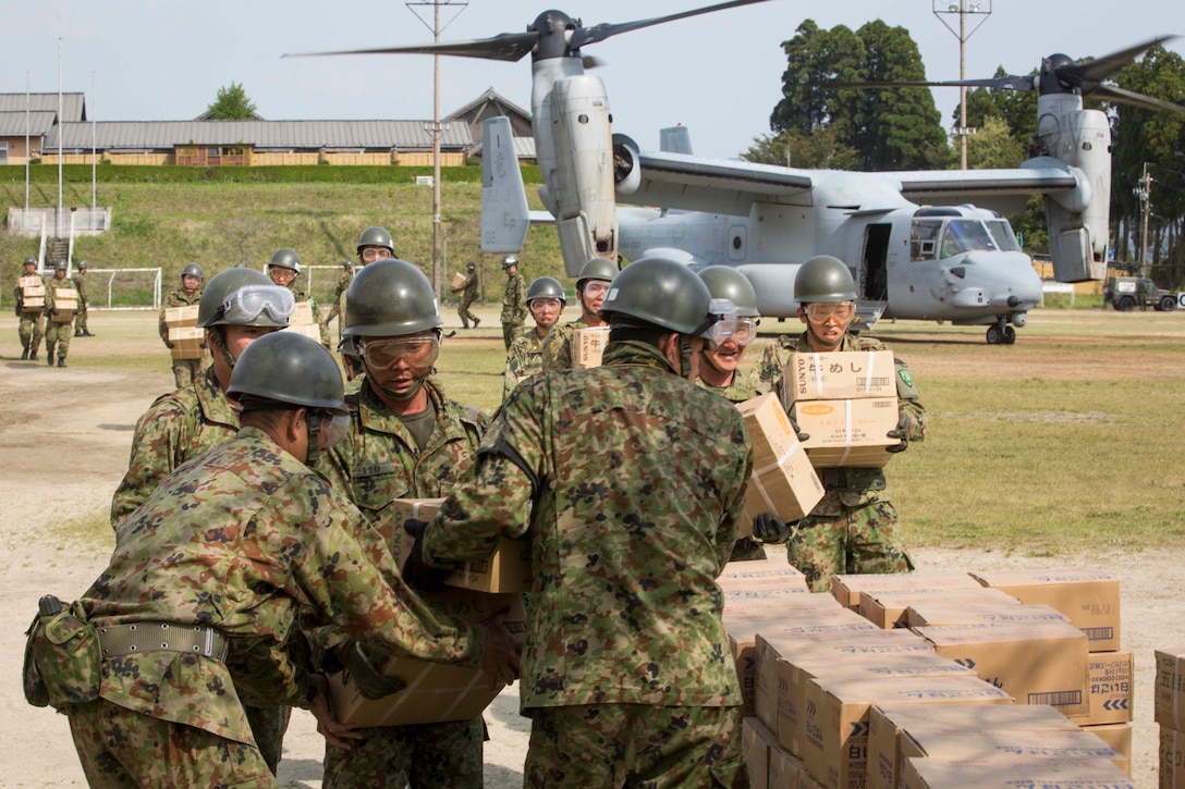 Japanese soldiers off load humanitarian aid from a U.S. Marine Corps MV-22B Osprey aircraft and stack the boxes at the Hakusui Sports Park, Kyushu island, Japan, April 20, 2016. Marine Corps photo by Cpl. Darien J. Bjorndal