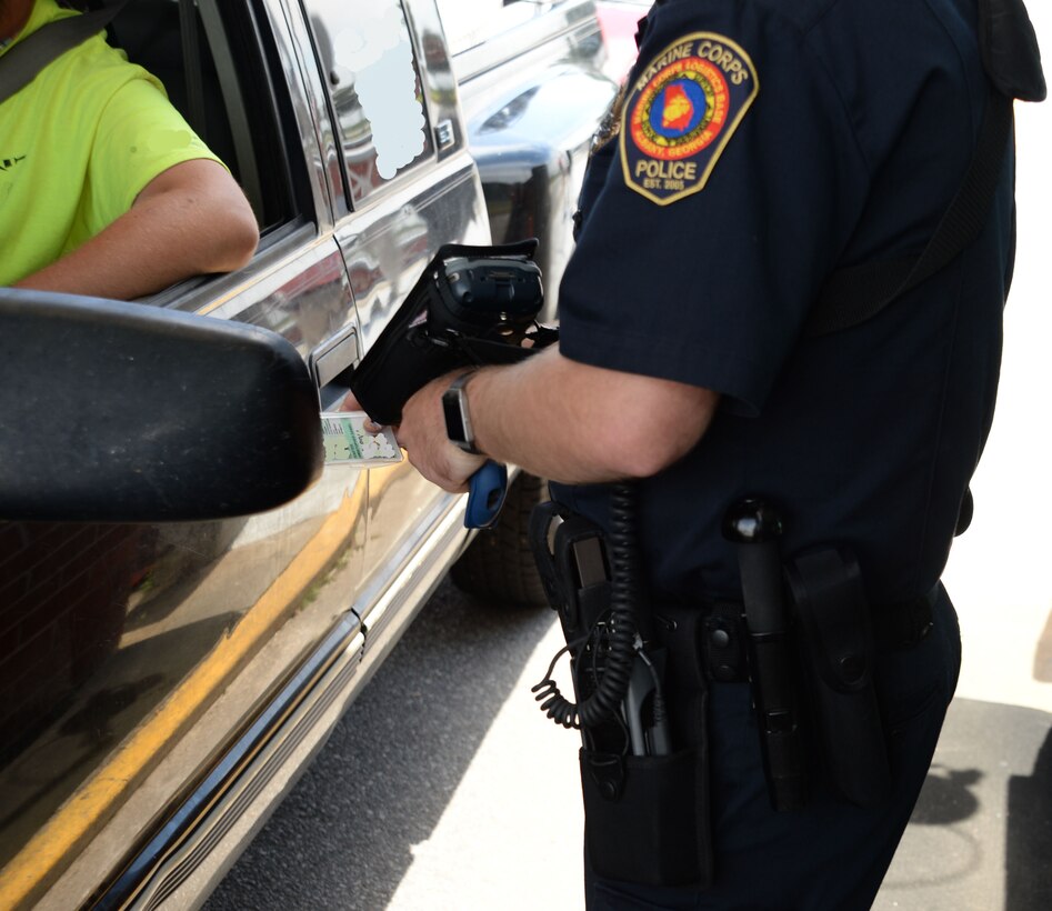 A law enforcement officer, Marine Corps Police Department, Marine Corps Logistics Base Albany, scans the identification card of a driver entering the base using the new RAPIDGate system April 20. The new scanners will provide an additional layer of security for base residents, personnel and patrons on the installation and will be in full-effect for all motorists seeking entrance at MCLB Albany’s sentry checkpoints once fully implemented, May 1.