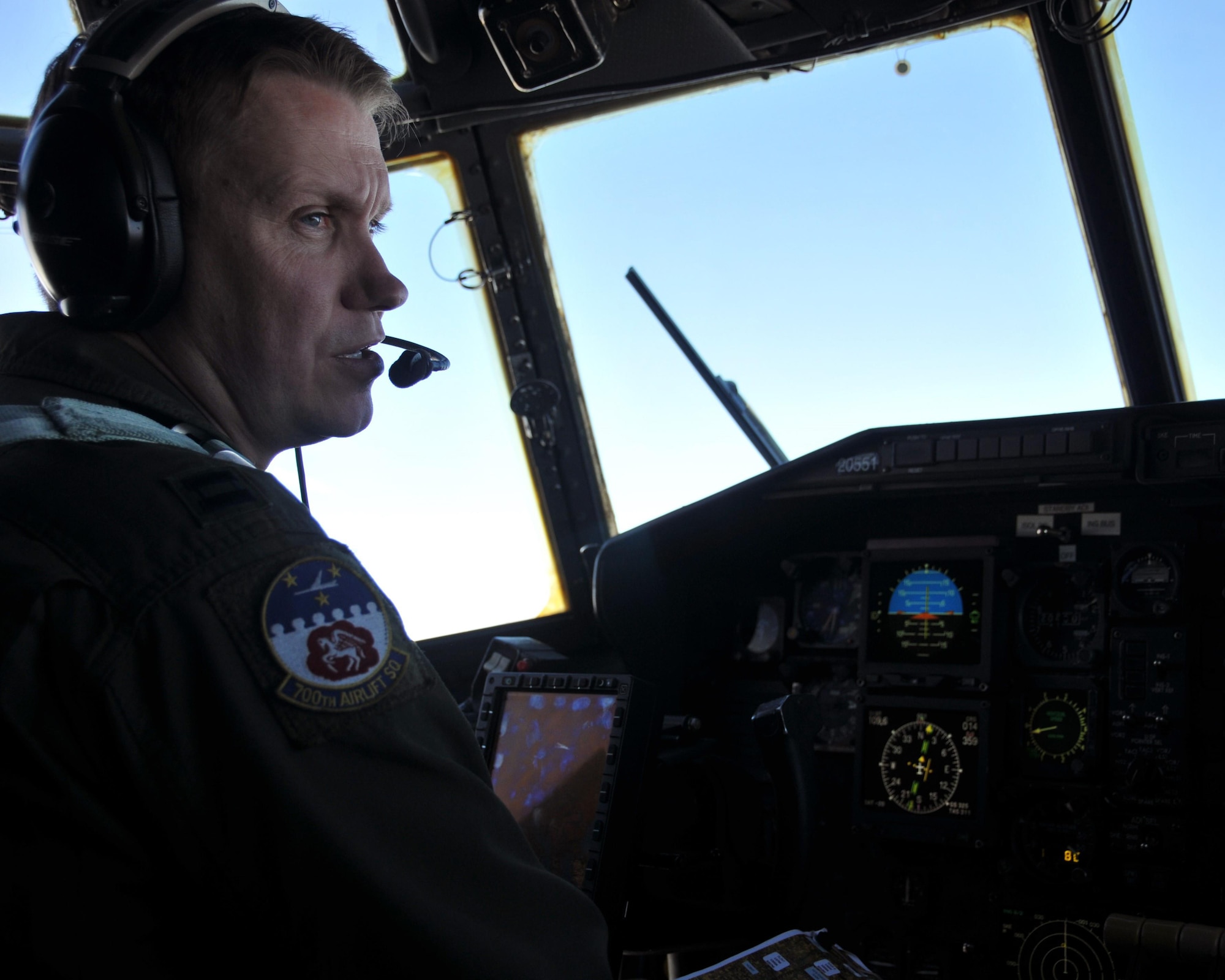 Capt. Jamie Atkinson, 700th Airlift Squadron C-130 aircraft commander, talks with the crew on the flight deck of the C-130 shortly after taking off from Aviano Air Base, Italy on April 11, 2016. The C-130 carried a fully-armored humvee, which it airdropped over Hohenfels Training Area, Germany. (U.S. Air Force photo/ Senior Airman Andrew J. Park)
