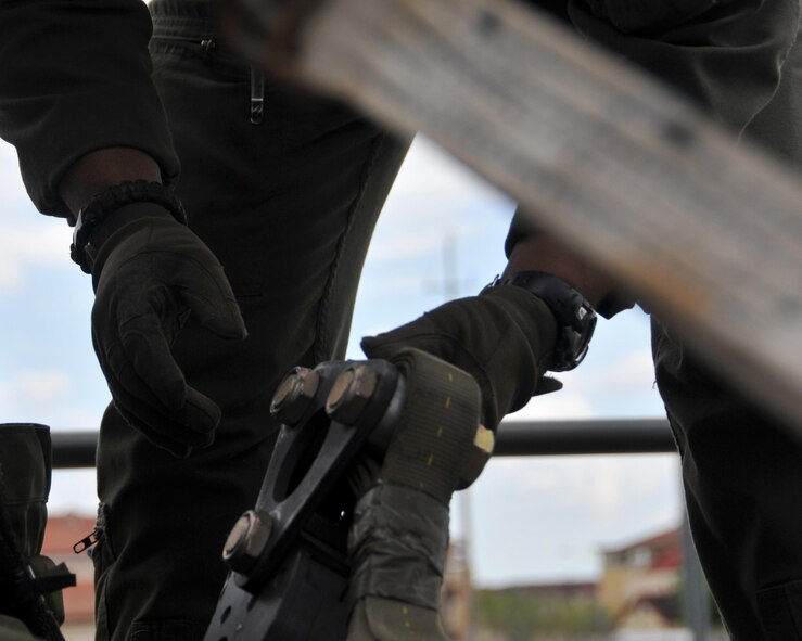 Staff Sgt. Wes Brown, 700th Airlift Squadron loadmaster, inspects the link that connects the extraction line to the extraction chute for the Humvee being loaded onto the C-130 Hercules at Aviano Air Base, Italy on April 10, 2016. The 94th Airlift Wing participated in Exercise Saber Junction 16 April 11-15. (U.S. Air Force photo/ Senior Airman Andrew J. Park)
