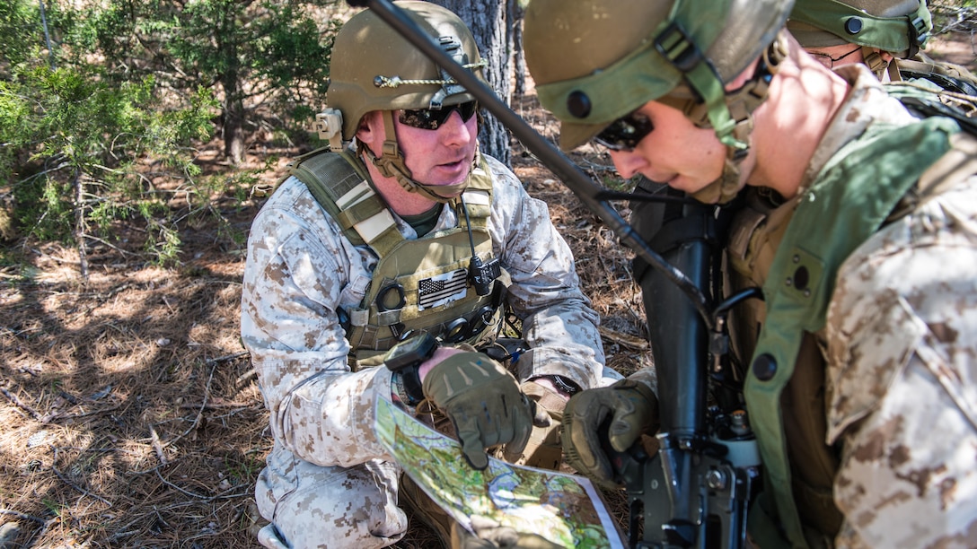 Gunnery Sgt. Joseph Clarkin, an instructor at the Marine Military Police Officers Basic Course, helps a student navigate during a three-day field training exercise at Fort Leonard Wood, Missouri, Apr. 13, 2016. The exercise evaluates the skills of students in an expeditionary environment. (Official Marine Corps photo by Lance Cpl. Julien Rodarte/Released)