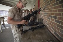Lance Corporal Royce Cappucilli, with 2nd Platoon, Charlie Company, Fleet Anti-Terrorism Security Team, Marine Corps Security Forces Regiment, inspects his weapon before turning it in to the armory aboard Camp Allen, in Norfolk, Virginia, 13 April, after returning from a four-month deployment to Guantanamo Bay, Cuba. The Marines from Charlie Company posted security along the fence line and stood post in guard towers at Guantanamo Bay Naval Base, while conducting land navigation exercises, going to rifle and weapons ranges and engaging in weapons system sustainment training. (U.S. Marine Corps photo by Cpl. Calvin Shamoon/Unreleased)