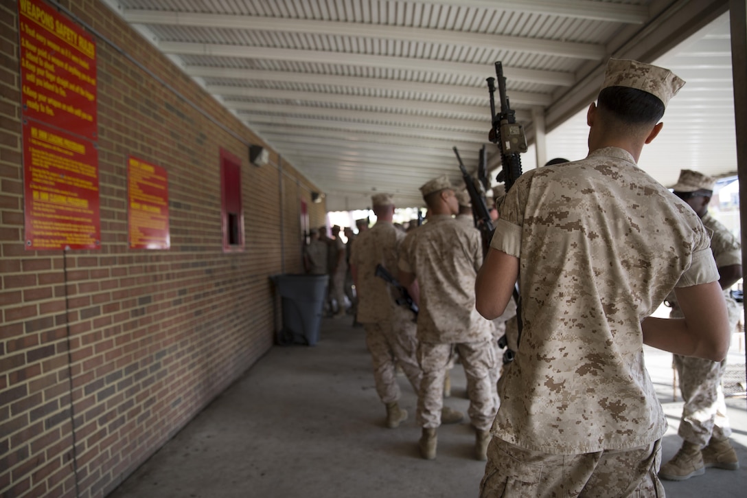 Marines with 2nd platoon Charlie Company Fleet, Anti-Terrorism Security Team, Marine Corps Security Forces Regiment, stand by to turn in weapons at the armory on Camp Allen, Norfolk, Virginia, 13 April, after returning from a four month deployment to Guantanamo Bay, Cuba. The Marines from Charlie Company posted security along the fence line and stood post in guard towers at Guantanamo Bay Naval Base, while conducting land navigation exercises, going to rifle and weapons ranges and engaging in weapons system sustainment training. (U.S. Marine Corps photo by Cpl. Calvin Shamoon/Unreleased)