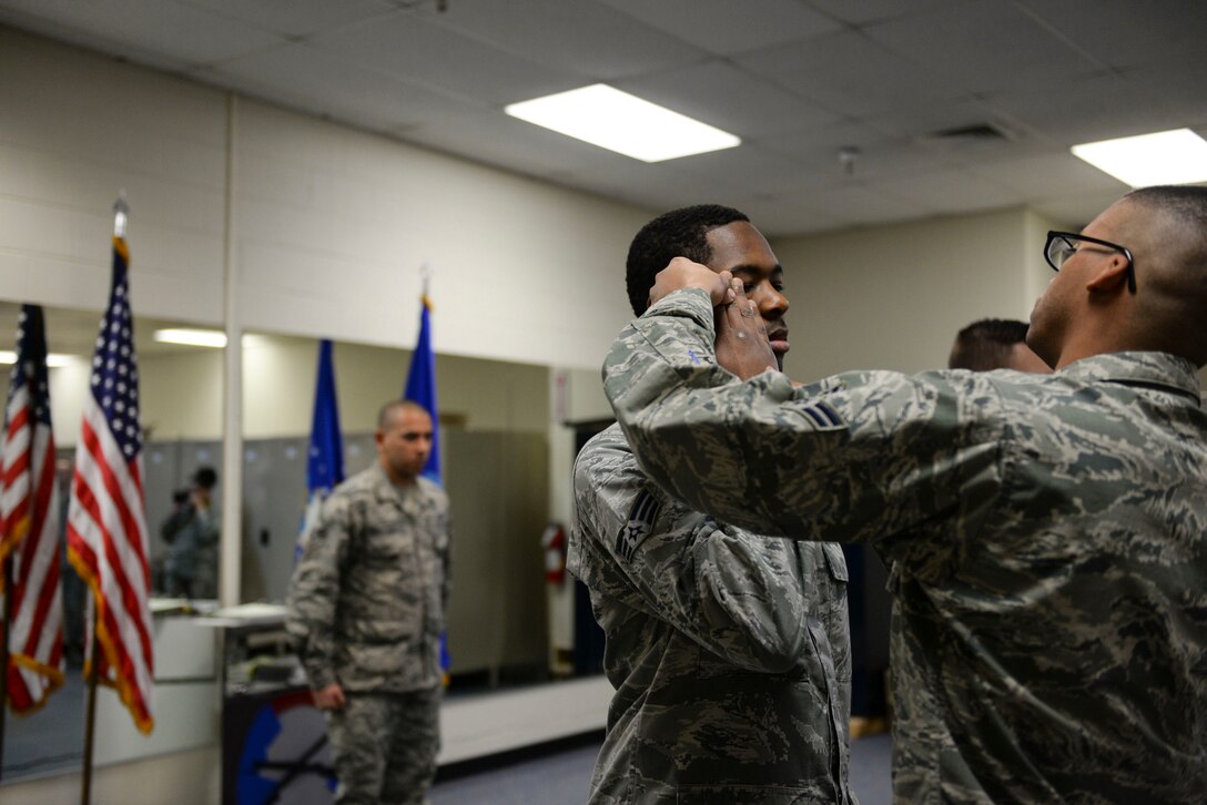 Base honor guard flight lead, Senior Airman Radames Rivera Rodriguez critiques potential honor guardsmen as older members perfect their salute at Mountain Home Air Force Base, Idaho, March 3, 2016. For Rivera, letting go of basic training techniques and learning to perfect rifle manuevers was most difficult for him as a new honor guardsman. (U.S. Air Force photo by Senior Airman Jessica H. Evans/RELEASED)