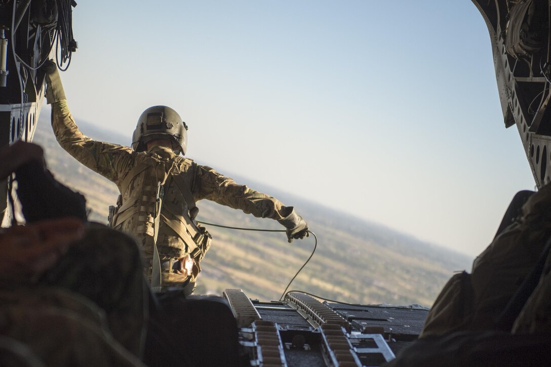 An Army aircrewman sits at the edge of a CH-47 Chinook helicopter during transit from Baghdad International Airport, April 20, 2016. DoD photo by Navy Petty Officer 2nd Class Dominique A. Pineiro