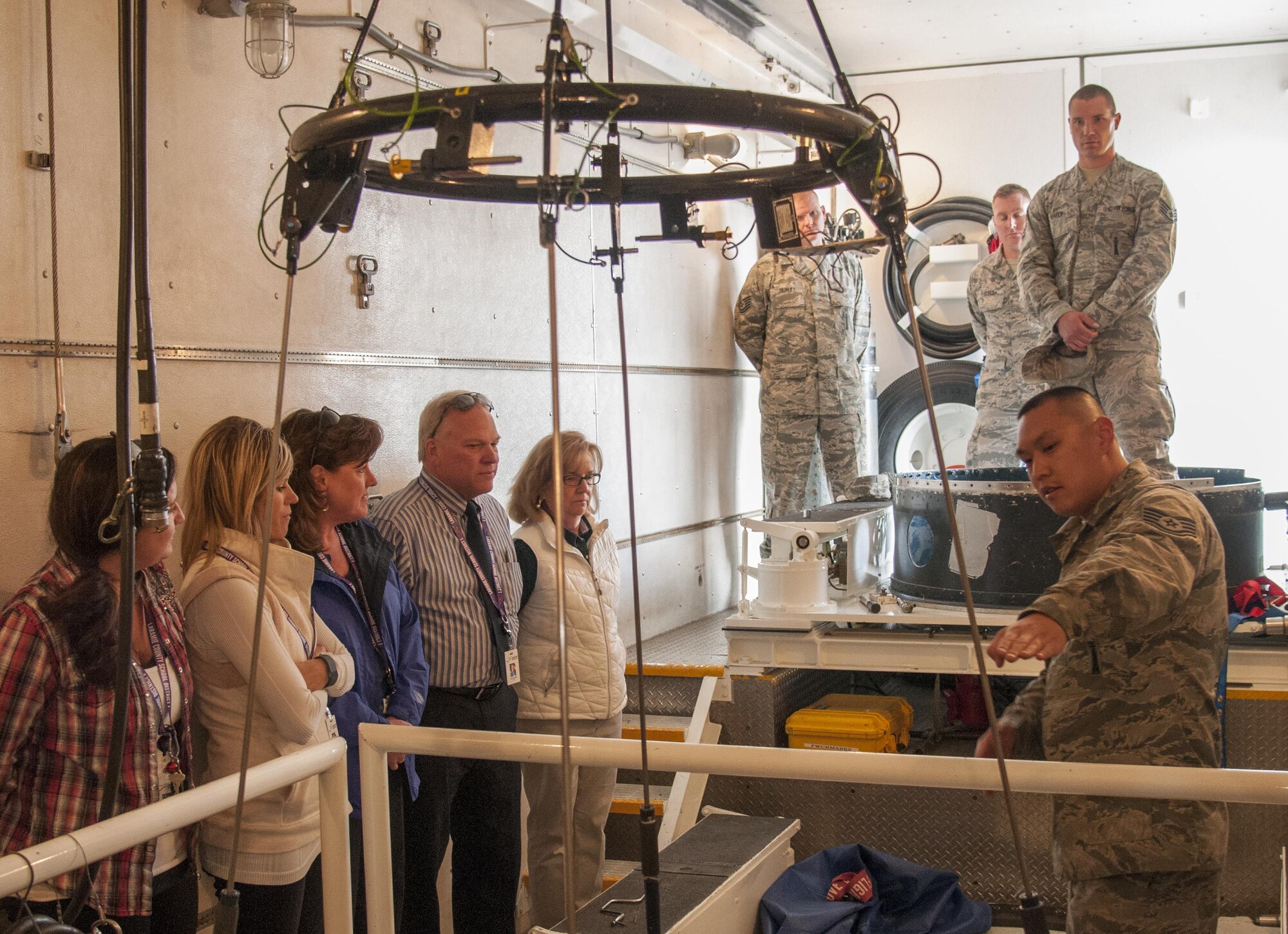 Staff Sgt. Adam Pruitt, 790th Maintenance Squadron missile maintenance technician topside instructor, shows a group of local educators the inside of a payload transport on F.E. Warren Air Force Base, Wyo., April 19, 2016. The educators teach and look after many of the children of on-base residents. (U.S. Air Force photo by Senior Airman Jason Wiese)