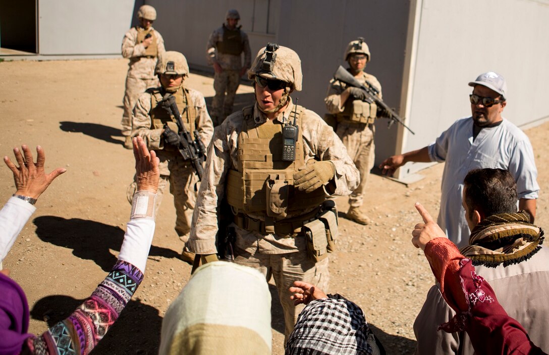 MARINE CORPS BASE CAMP PENDLETON, Calif. – Sgt. Travis M. Ryan interacts with role players as Marines from 7th Engineer Support Battalion provide security and conduct a simulated resupply at Camp Pendleton March 25, 2016. The convoy training consisted of three phases: Marines performing crowd control while refueling a patrol base, immediate action drills from hostile fire and casualty evacuation from a helicopter landing zone. Ryan, a native of Rathdrum, Idaho, is a combat engineer with 7th ESB, 1st Marine Logistics Group. (U.S. Marine Corps photo by Lance Cpl. Justin E. Bowles/ Released)