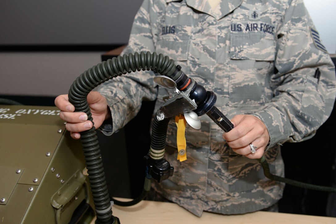 U.S. Air Force Tech. Sgt. Jennifer Ellis, aerospace and operational physiology flight chief assigned to the 633rd Aerospace Medicine Squadron, demonstrates the use of a Reduced Oxygen Breathing Device equipment at Langley Air Force Base, Va., April 19, 2016. The ROBD is worn like a normal oxygen mask; however, physiologists can change the gas in the mask to mirror the effects of hypoxia. (U.S. Air Force photo by Airman 1st Class Kaylee Dubois)