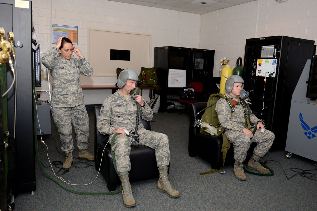 U.S. Air Force Senior Airman Francia Holt, an aerospace and operational physiology technician assigned to 633rd Aerospace Medicine Squadron, prepares to lead Chief Master Sgt. Todd Popovic, a pararescueman, and Maj. David McGraw, a combat rescue officer, both assigned to Air Combat Command, in an oxygen deprivation simulation at Langley Air Force Base, Va., April 19, 2016. Aircrew members are taught to watch out for vision loss, confusion, slurred speech and unconsciousness, which are all caused by a lack of oxygen. (U.S. Air Force photo by Airman 1st Class Kaylee Dubois)