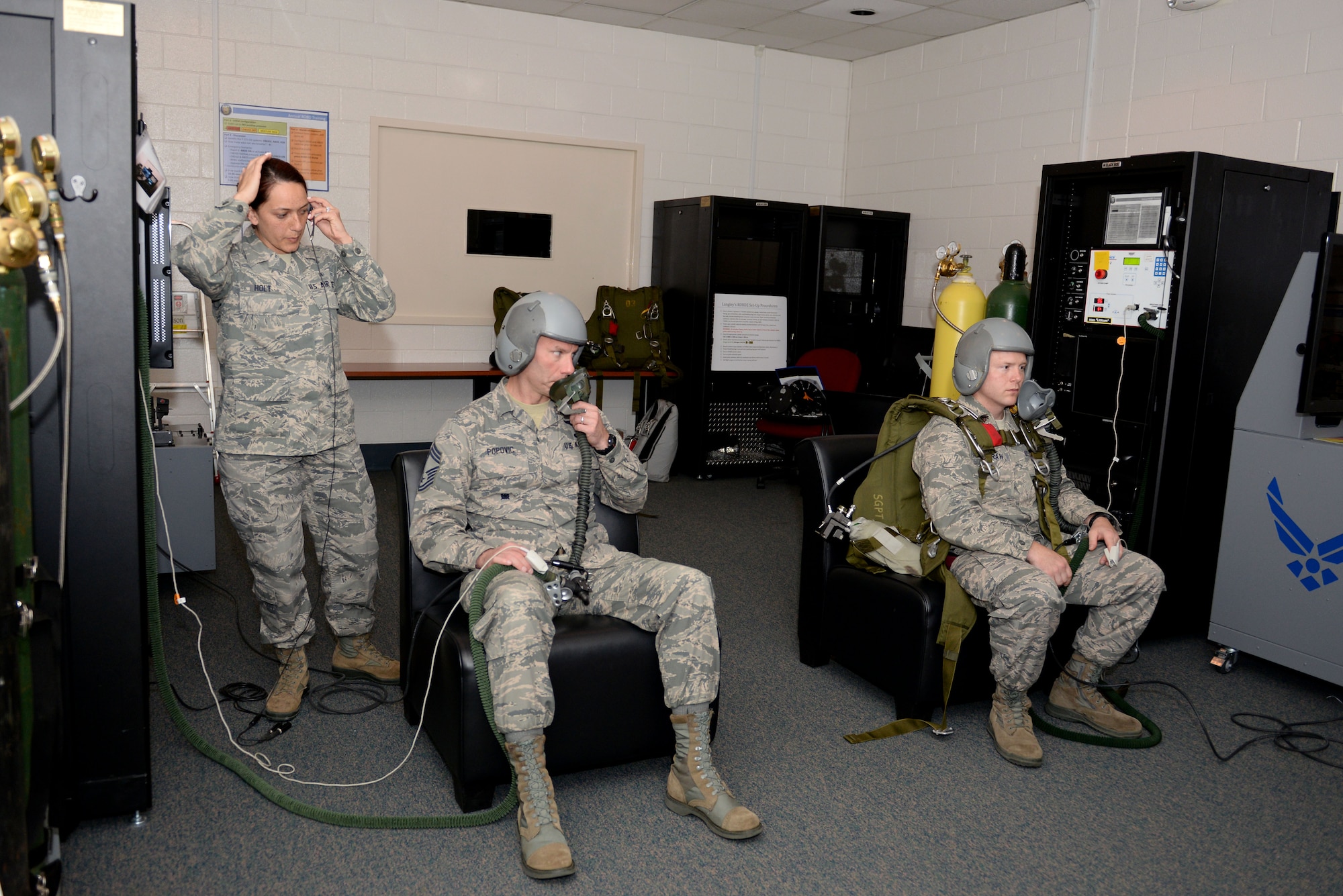 U.S. Air Force Senior Airman Francia Holt, an aerospace and operational physiology technician assigned to 633rd Aerospace Medicine Squadron, prepares to lead Chief Master Sgt. Todd Popovic, a pararescueman, and Maj. David McGraw, a combat rescue officer, both assigned to Air Combat Command, in an oxygen deprivation simulation at Langley Air Force Base, Va., April 19, 2016. Aircrew members are taught to watch out for vision loss, confusion, slurred speech and unconsciousness, which are all caused by a lack of oxygen. (U.S. Air Force photo by Airman 1st Class Kaylee Dubois)