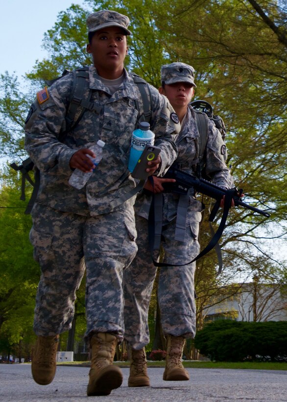 U.S. Army Sgt. Anais Fisher, a motor transport operator rucks with her sponsored Soldier, Spc. Diamantina Hernandez, a cargo specialist assigned to the 690th Rapid Port Opening Element, during the 597th Transportation Brigade Best Warrior Competition at Fort Eustis, Va., April 15, 2016. Each Soldier marched 12 miles wearing a ruck sack weighing 35 pounds. and an M-4 carbine. (U.S. Air Force photo by Staff Sgt. J.D. Strong II)