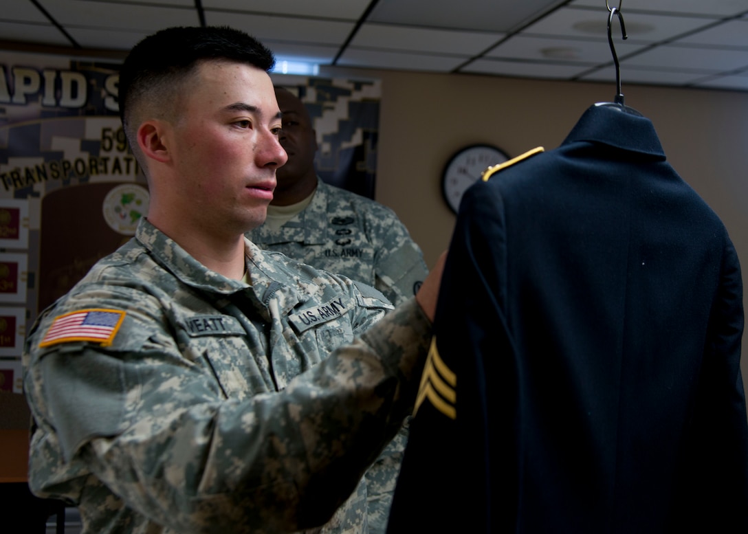 U.S. Army Pfc. David Sweatt, a chemical, biological, radiological, nuclear specialist assigned to the 688th Rapid Port Opening Element, fixes discrepancies on an Army dress uniform during the 597th Transportation Brigade Best Warrior Competition at Fort Eustis, Va., April 15, 2016. Finding the discrepancies in the female dress uniform was a mystery event; the Soldiers’ had no idea what the event was until they entered the room.(U.S. Air Force photo by Staff Sgt. J.D. Strong II)