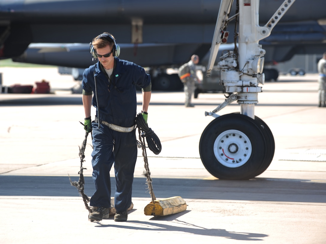 U.S. Air Force Staff Sgt. Robert Gallagher, 7th Aircraft Maintenance Squadron crew chief, removes the blocks on a B-1B Lancer during Exercise Constant Vigilance 16, April 10, 2016, at Dyess Air Force Base, Texas. The exercise included simultaneous elements that tested and refined Air Force Global Strike Command’s policies, training and techniques at the tactical and operational levels. (U.S. Air Force photo by Airman 1st Class Rebecca Van Syoc/Released)
