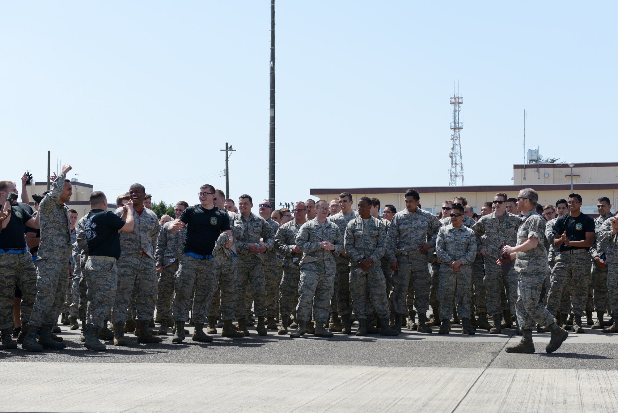 Members of the 374th Maintenance Operations Flight cheer when hearing of their victory during a portion of the 374th Maintenance Group Rodeo Competition at Yokota Air Base, Japan, April 15, 2016. The final task required the participating teams consisting of 20 members to pull a C-130 Hercules with a rope. The winning team was rewarded with points that go toward the Spirit Award, an internal award given to the overall rodeo winner. (U.S. Air Force photo by Staff Sgt. Cody H. Ramirez/Released)