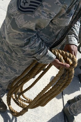 An Airman coils a rope after members of the 374th Maintenance Group used it to pull a C-130 Hercules at Yokota Air Base, Japan, April 15, 2016. The C-130 pull was one of many challenges within the 374 MXG Maintenance Rodeo Competition. (U.S. Air Force photo by Staff Sgt. Cody H. Ramirez/Released)