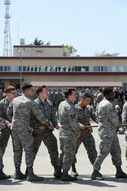 Members of the 374th Aircraft Maintenance Squadron prepare to pull a C-130 Hercules at Yokota Air Base, Japan, April 15, 2016. Points were awarded to the team that pulled the C-130 the farthest, going toward a total rodeo score. The overall winner of the rodeo wins a Spirit Award and bragging rights. (U.S. Air Force photo by Staff Sgt. Cody H. Ramirez/Released)