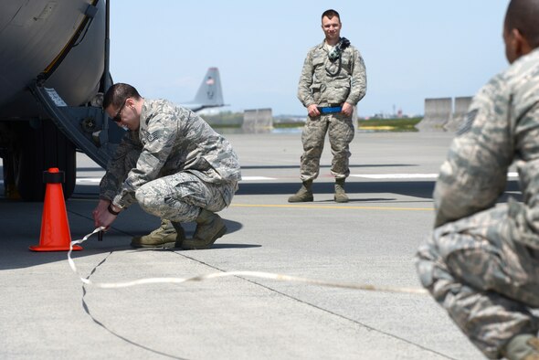 Judges measure the distance a C-130 Hercules was pulled during a 374th Maintenance Group Maintenance Rodeo Competition at Yokota Air Base, Japan, April 15, 2016. Three teams, each representing a different squadron of the 374 MXG, pulled a C-130 to win points toward a Spirit Award, an internal award given to the 'best' squadron. (U.S. Air Force photo by Staff Sgt. Cody H. Ramirez/Released)