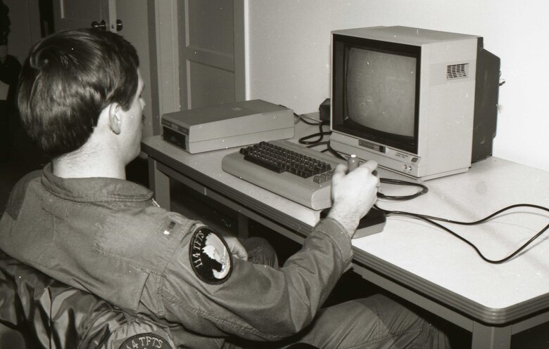 An F-4 Phantom student pilot uses one of the first computer systems at Kingsley Field in 1986.  When the F-4 school house started at the 114th Tactical Fighter Training Squadron, computers were a novelty and used on a minimal bases.  Computers and network security are now an integral piece of everyday training and operations. (U.S. Air National Guard Senior Airman Amber Powell)