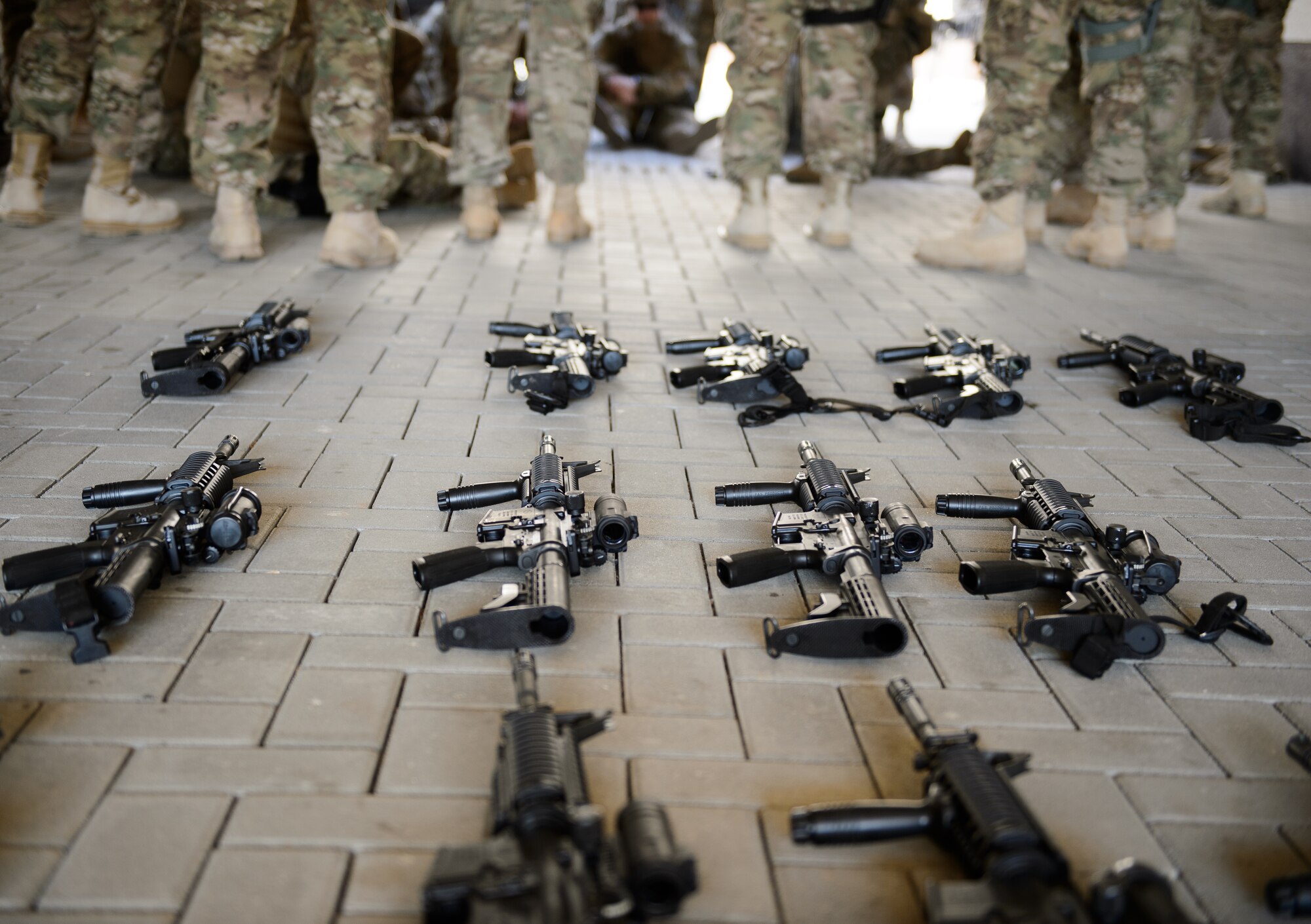 Weapons lay on the ground as Airmen wait for training to begin April 11, 2016 at Ramstein Air Base, Germany. The Airmen participated in a variety of tasks in order to prepare for an upcoming deployment where they would execute one of their primary missions of building a base from the ground up. (U.S. Air Force photo/Staff Sgt. Armando A. Schwier-Morales)