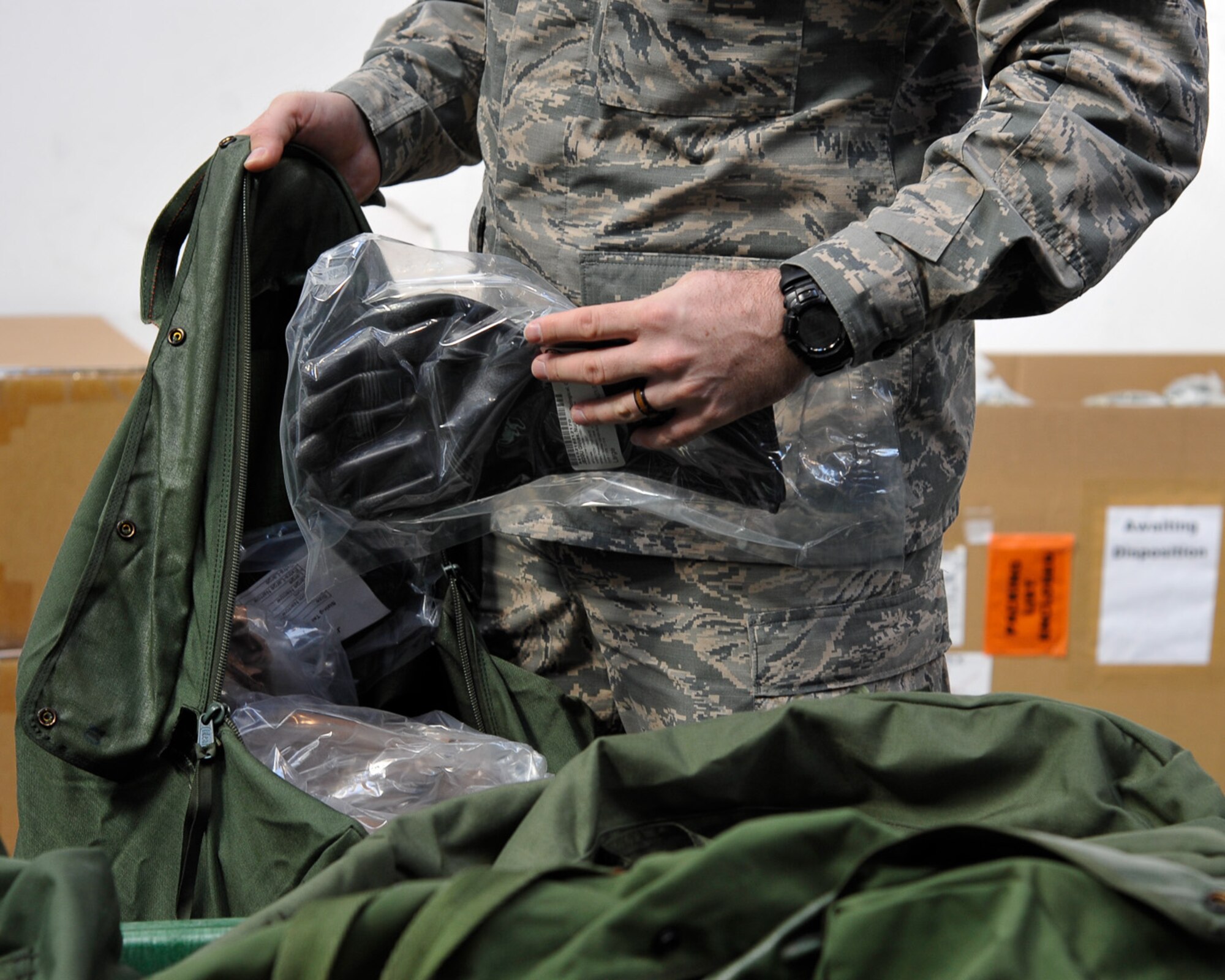 An Airman from the 86th Aerospace Medicine Squadron puts protective gloves into a chemical gear bag during an individual protective equipment issue during Wing Thunder, April 20, at Ramstein Air Base, Germany. The 86th Logistics Readiness Squadron processed more than 100 chemical gear issues for personnel around Team Ramstein. Wing Thunder is an inspection used to ensure Team Ramstein and personnel are prepared for unforeseen circumstances. (U.S. Air Force photo/Staff Sgt. Leslie Keopka)