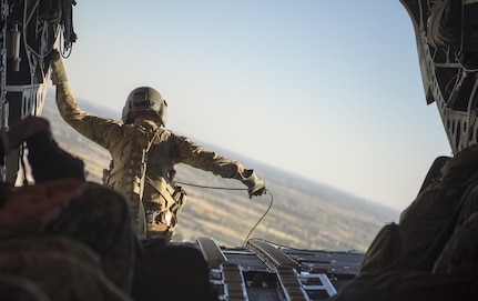 An Army aircrewman sits at the edge of a CH-47 Chinook helicopter during transit from Baghdad International Airport, April 20, 2016. DoD photo by Navy Petty Officer 2nd Class Dominique A. Pineiro