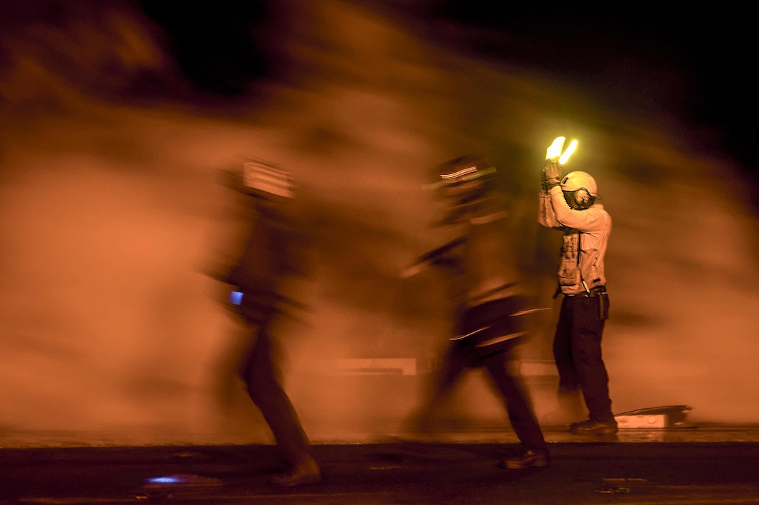 Navy Petty Officer 1st Class Elgin Sanders, right, guides aircraft on the flight deck of the USS Harry S. Truman in the Arabian Gulf, April 15, 2016. The Harry S. Truman Carrier Strike Group is supporting Operation Inherent Resolve and other security efforts in the U.S. 5th Fleet area of responsibility. Navy photo by Petty Officer 2nd Class Ethan T. Miller