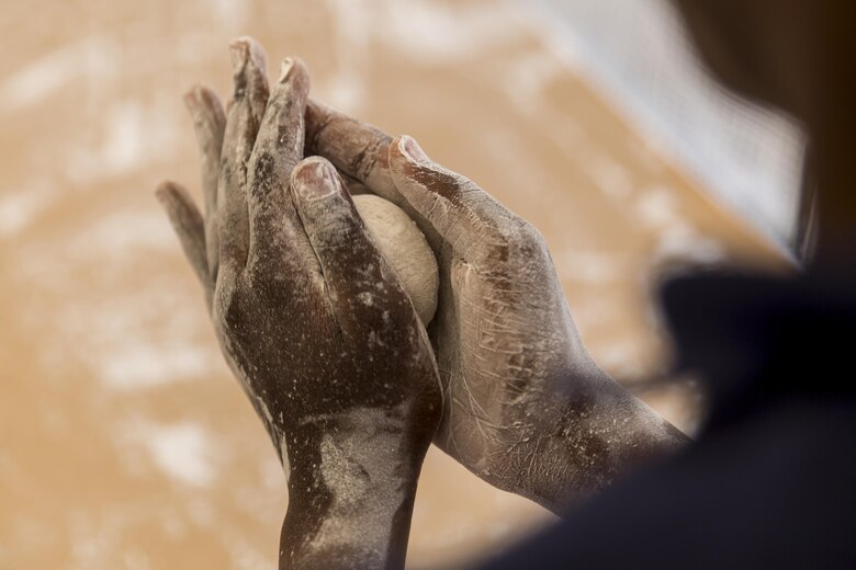 A resident from Marine Corps Air Station Iwakuni rolls mochi during a Mochitsuki – rice pounding – event at Tenno Elementary School in Tenno, Japan, April 16, 2016. Commonly eaten during the Japanese New Year and festivals, mochi is made when glutinous rice is soaked, steamed and pounded with a wooden mallet and mortar, forming a sticky, stretchy texture. (U.S. Marine Corps photo by Lance Cpl. Aaron Henson/Released)