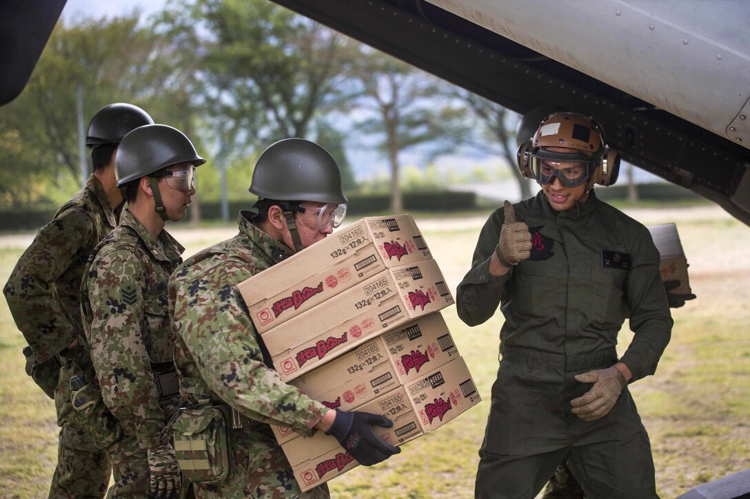 Marine Corps Cpl. Luis R. Diaz gives a "thumbs-up" to a Japanese soldier while unloading an MV-22B Osprey aircraft at Haksui Sports Park in Minamiaso, Japan, April 20, 2016. Diaz is assigned to Marine Medium Tiltrotor Squadron 265, Reinforced, 31st Marine Expeditionary Unit. Marine Corps photo by Sgt. Royce Dorman