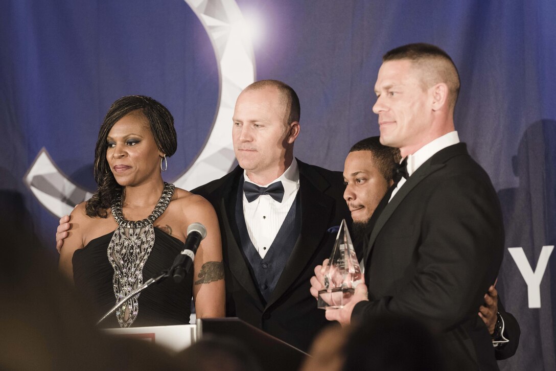 Professional wrestler John Cena is joined on stage by veterans and fellow cast members of the Fox television show 'True Grit,' during the USO Metropolitan Washington-Baltimore annual awards dinner, in Arlington, Va., April 19, 2016. Cena was presented the USO's Legacy of Achievement Award, which is given to civilians who demonstrate a deep commitment to our nation's military and who have contributed to educating others about their service and sacrifice. DoD photo by Army Staff Sgt. Sean K. Harp