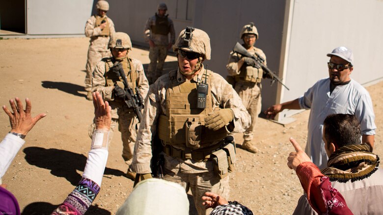 Sgt. Travis M. Ryan interacts with role players as Marines from 7th Engineer Support Battalion provide security and conduct a simulated resupply at Marine Corps Base Camp Pendleton March 25, 2016. The convoy training consisted of three phases: Marines performing crowd control while refueling a patrol base, immediate action drills from hostile fire and casualty evacuation from a helicopter landing zone. Ryan, a native of Rathdrum, Idaho, is a combat engineer with 7th ESB, 1st Marine Logistics Group. 