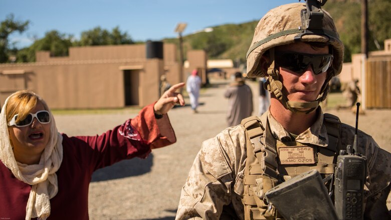 Cpl. Jarod B. Hodge provides security while interacting with simulated local nationals as Marines from 7th Engineer Support Battalion conducted a simulated resupply at Marine Corps Base Camp Pendleton March 25, 2016. The convoy training consisted of three phases: Marines performing crowd control while refueling a patrol base, immediate action drills from hostile fire and casualty evacuation from a helicopter landing zone. Hodge, a native of Greenville, Indiana, is a combat engineer with 7th ESB, 1st Marine Logistics Group. 