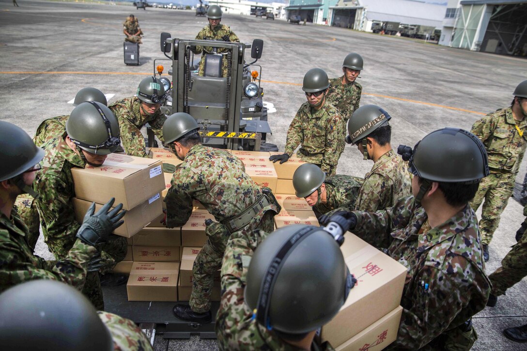 Japanese soldiers load relief supplies onto an MV-22B Osprey aircraft at Japanese Camp Takayubaru near the Aso-Kumamoto airport, Japan, April 20, 2016. Marine Corps photo by Sgt. Royce Dorman